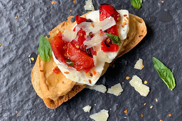 Toasted ciabatta, Sabra Roasted Red Pepper Hummus, marinated mozzarella, roasted red peppers, Parmigiano-Reggiano and chile flakes